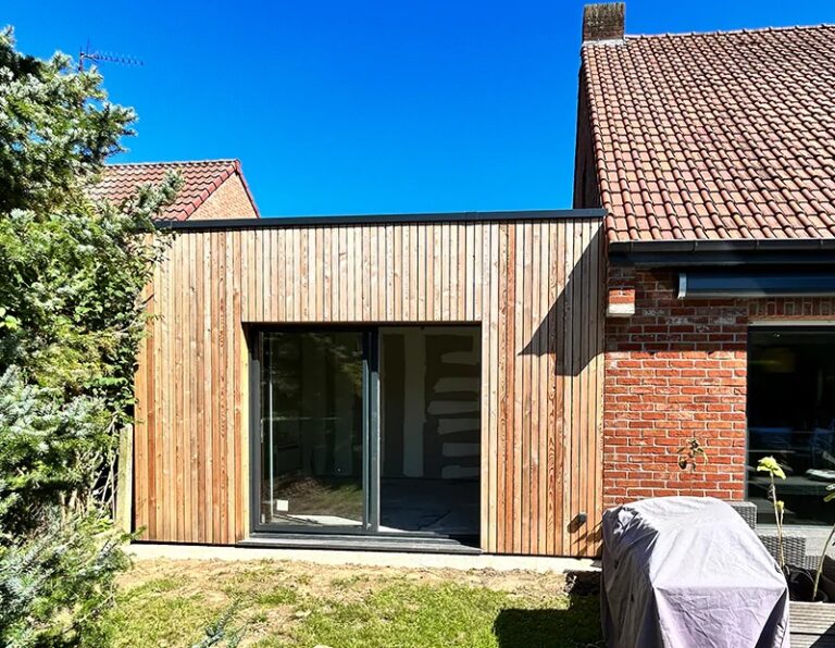 Extension de maison : tous les types pour agrandir sans déménager 1 Extension de plain-pied en bardage bois accolée à une maison en brique, avec grande baie coulissante