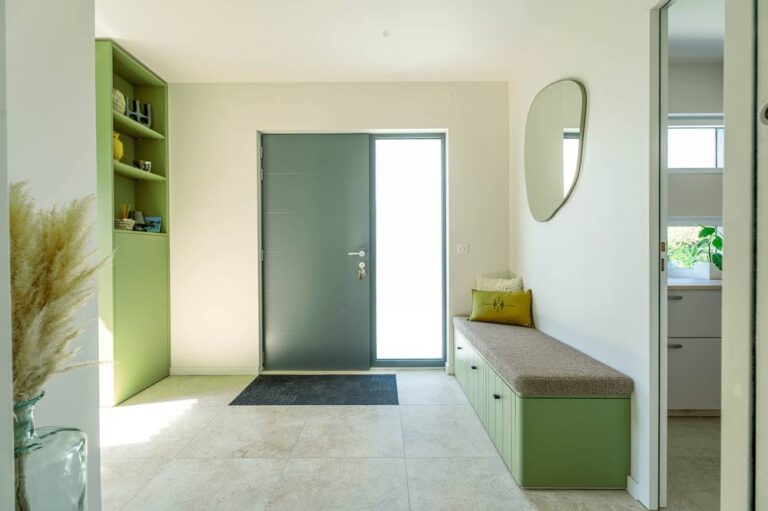 Extension maison toit plat : agrandissez en bois, en kit ou avec pose 5 Entrée aménagée avec banc et rangements sur mesure dans une extension bois
