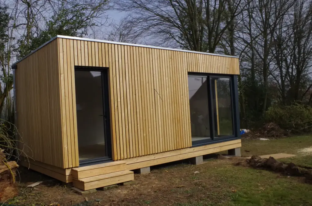 Studio de jardin en kit en ossature bois avec bardage vertical et terrasse en bois