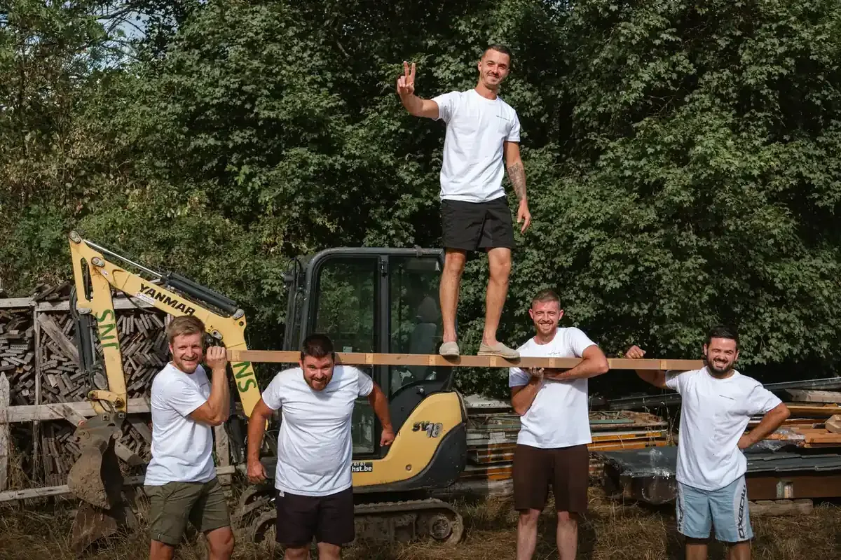 Les poseurs de Mon Extension Bois portant une poutre en bois