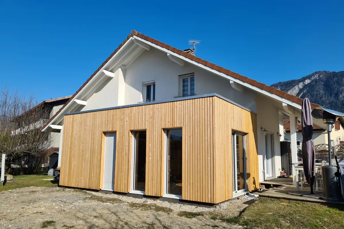 Extension bois en Lorraine 8 Extension en mélèze à toit plat accolée à une maison enduite à Cluses, en Haute-Savoie
