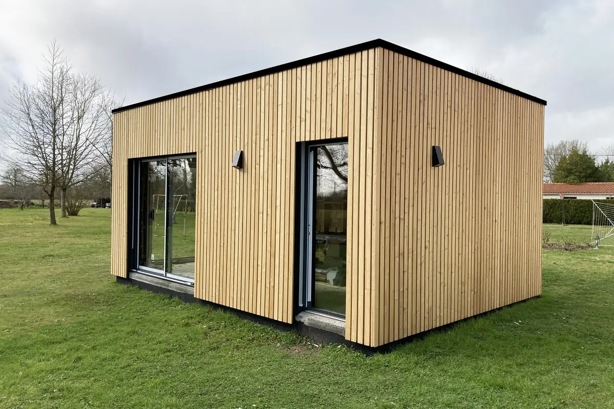Construction en ossature bois à toit plat avec deux baies vitrées dans un jardin à Saint-Mars-de-Coutais, réalisée par Mon Extension Bois