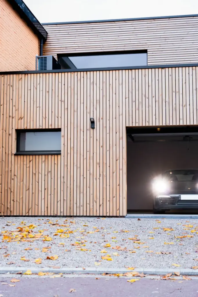 Garage bois porte ouverte, phares allumés à l'intérieur