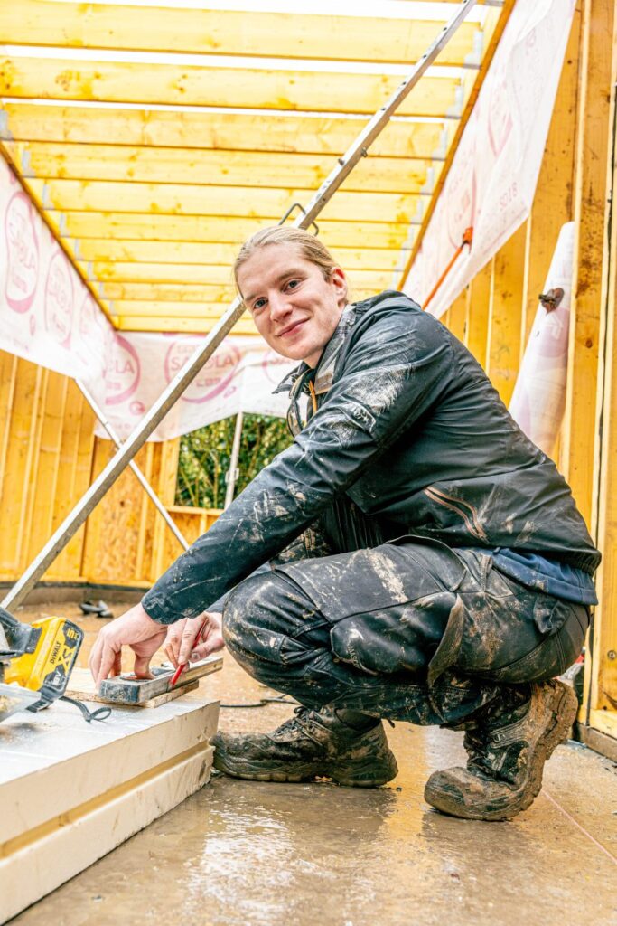 Montage d’une extension bois en kit : contrôle au niveau et traçage sur la dalle