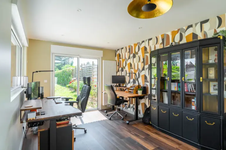 Extension de maison : tous les types pour agrandir sans déménager 12 Bureau aménagé dans l'extension bois de 25 m² à Louvil : poste de travail, bibliothèque et baie sur le jardin