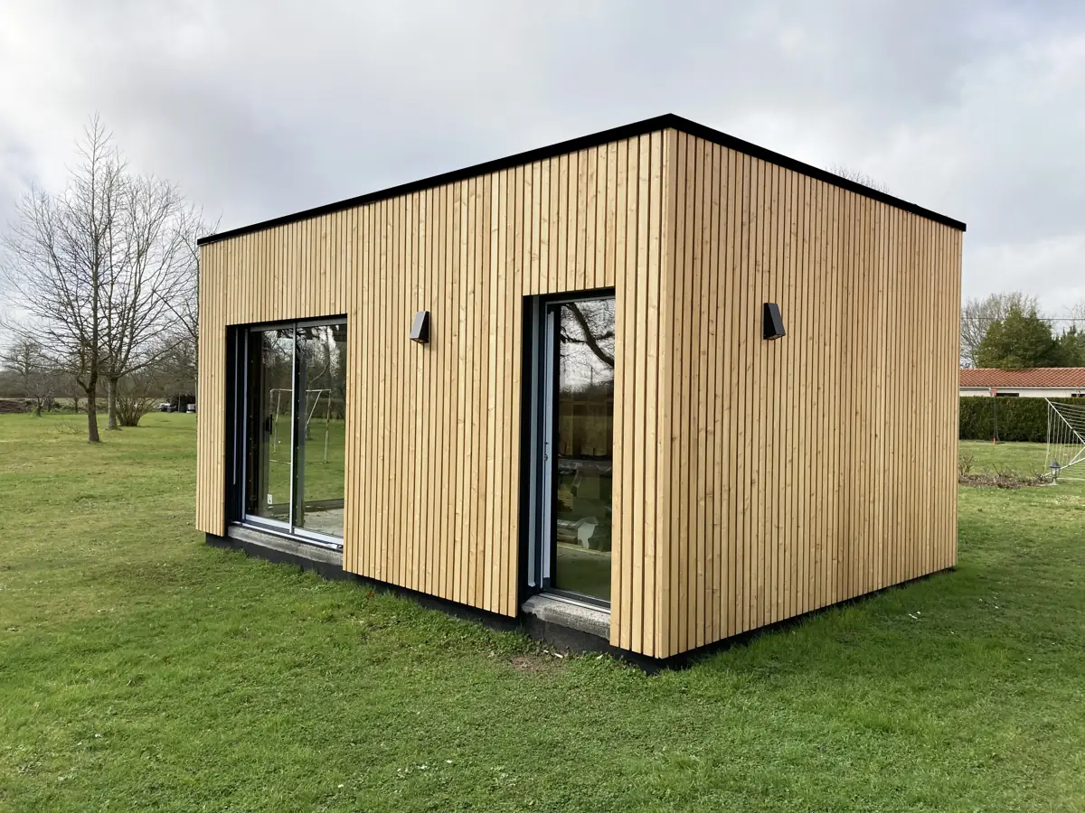 Extension de maison : tous les types pour agrandir sans déménager 6 Dépendance en ossature bois posée dans le jardin, bardage mélèze vertical et baies vitrées