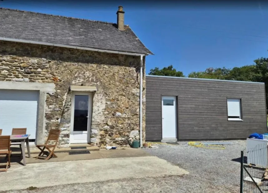 Extension en bois à bardage horizontal accolée à une maison en pierre