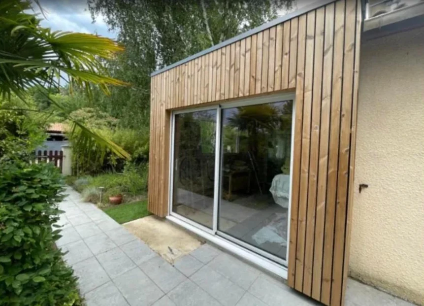 Mon Extension Bois Bordeaux 14 Baie coulissante et bardage vertical en bois d’une extension, terrasse dallée et jardin