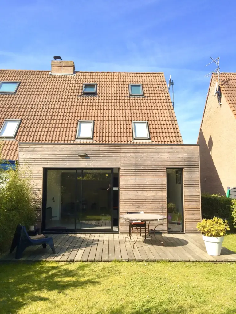 Extension bois avec grande baie vitrée et terrasse bois sur un pavillon à toit de tuiles
